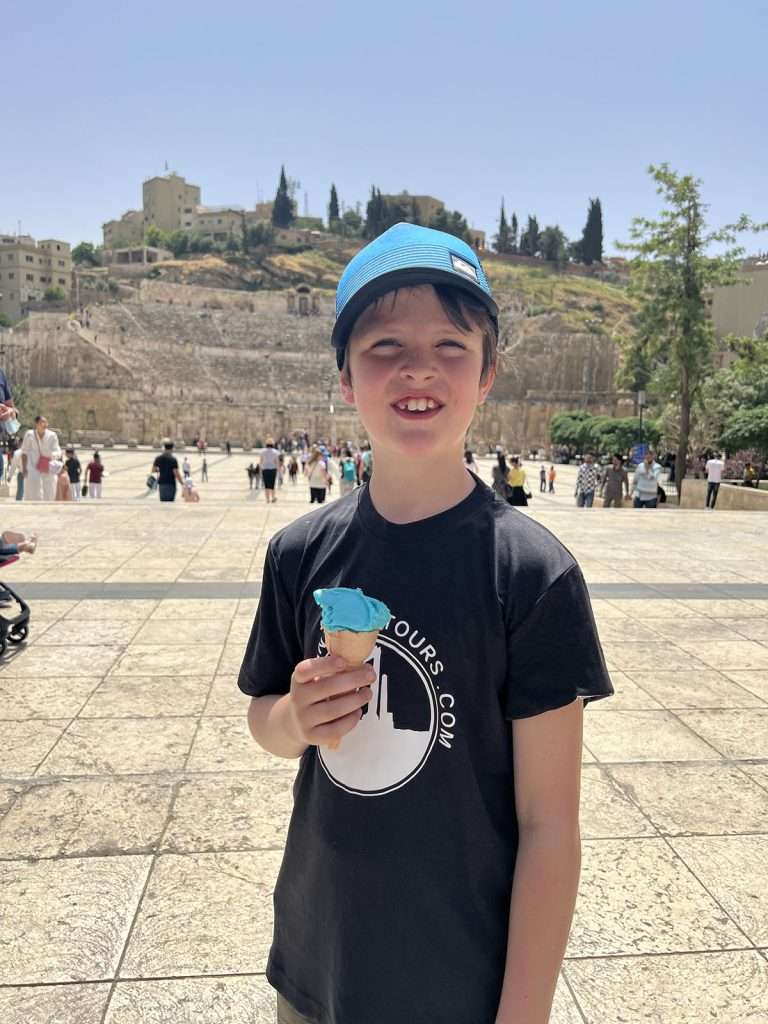 Roman Theatre in Amman with kid holding a blue Icecream