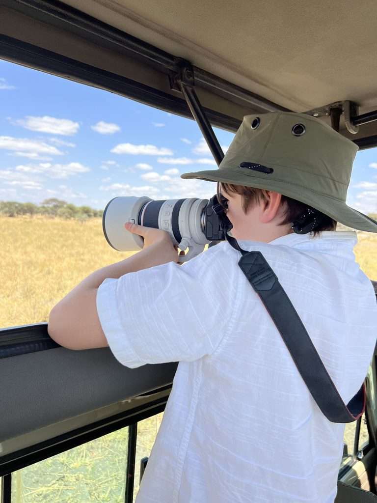 Child taking a photo from the car in tanzania