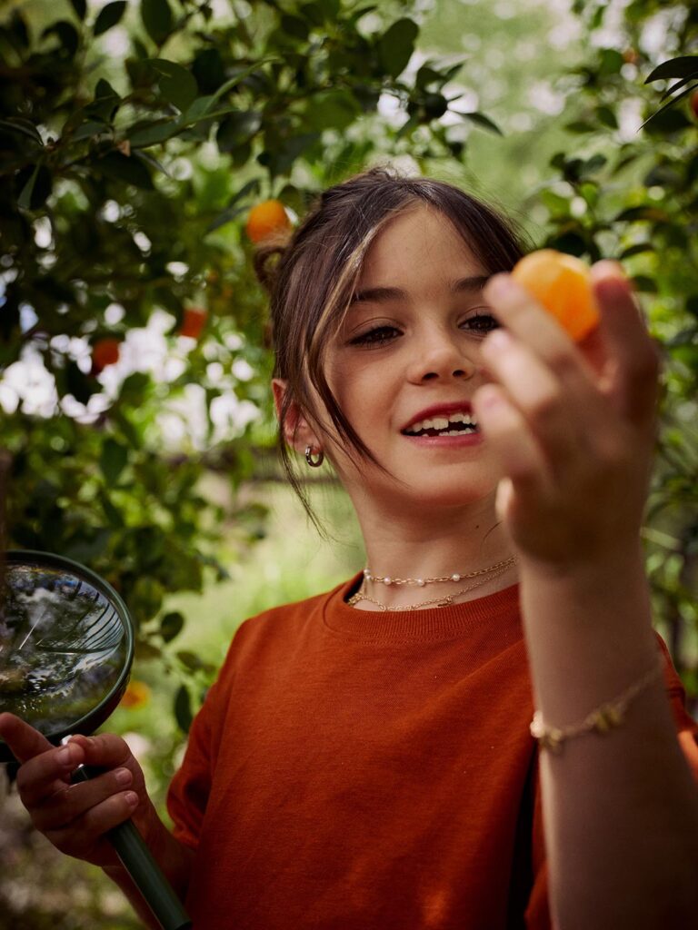 Loews Discovery Days in action girl looking at fruit tree outdoors