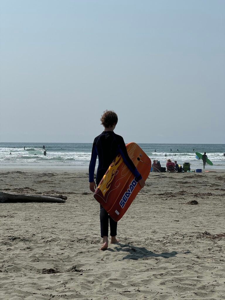 Tofino beach with a boy and a boogie board
